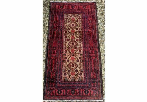An antique Balouch tribal carpet featuring a cream central field with geometric diamond motifs surrounded by a deep red and navy blue geometric border. View VII
