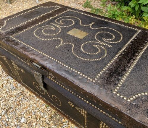 A dark brown leather rectangular coffer decorated with brass stud patterns, scrolling motifs, and a central metal latch. View III