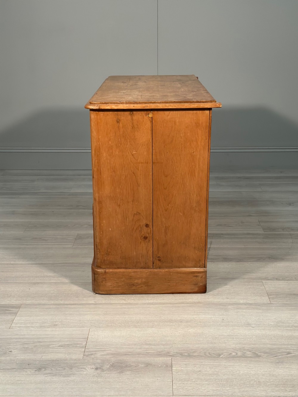 A nineteenth-century Victorian pine chest of drawers featuring a two-over-two drawer configuration, turned wooden knobs, and a solid plinth base. View X