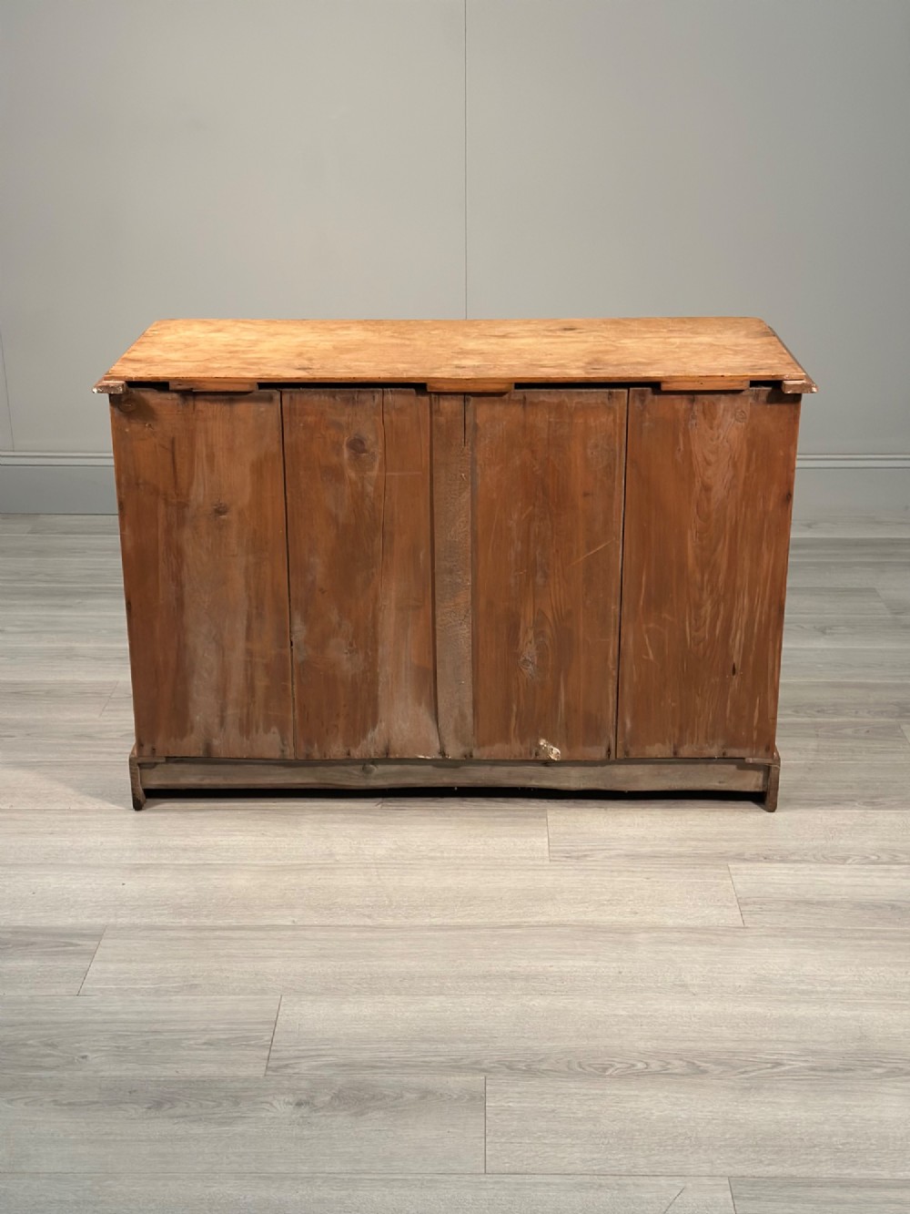 A nineteenth-century Victorian pine chest of drawers featuring a two-over-two drawer configuration, turned wooden knobs, and a solid plinth base. View XII