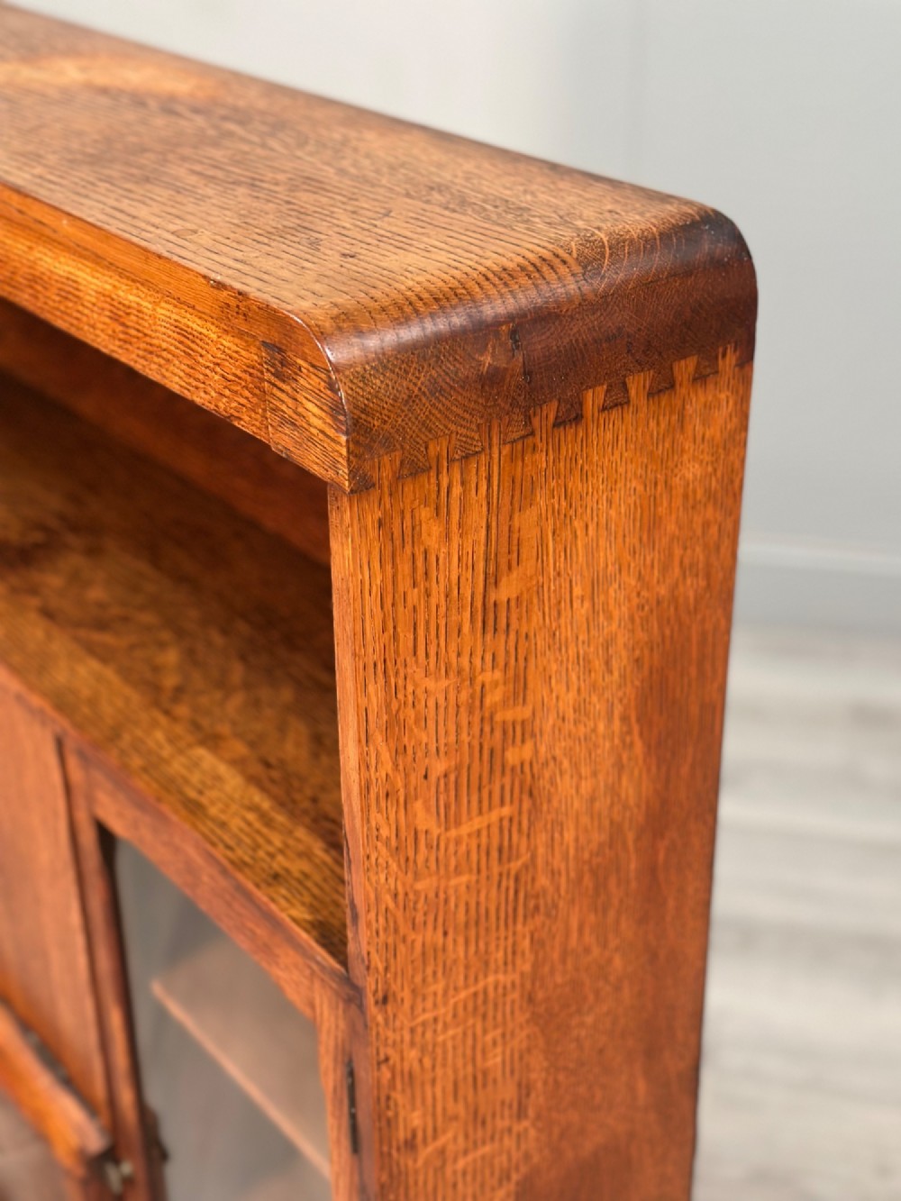 An Art Deco oak bureau bookcase featuring an open top shelf, drop-down writing flap, a glazed side cabinet, and lower cupboards with geometric diamond veneer. View IX