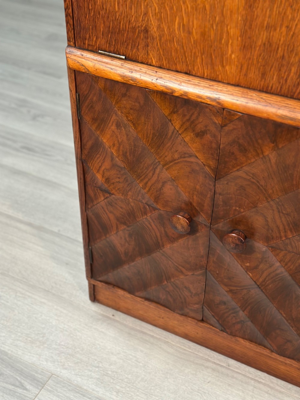 An Art Deco oak bureau bookcase featuring an open top shelf, drop-down writing flap, a glazed side cabinet, and lower cupboards with geometric diamond veneer. View X