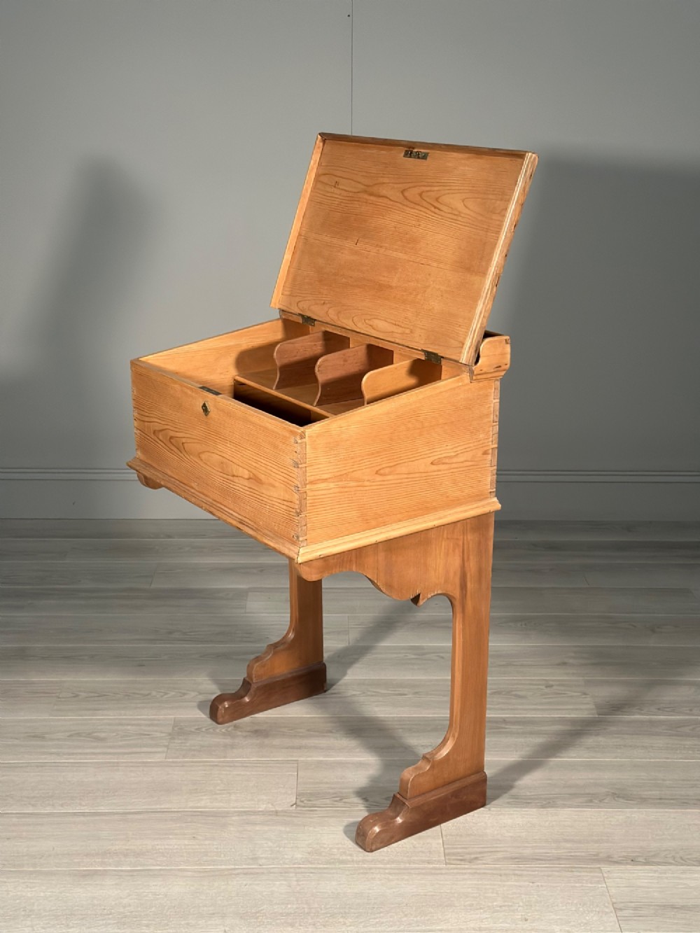 A Victorian pine school desk featuring a slanted hinged lid, dovetail joinery, shaped side supports, and a raised back gallery. View III