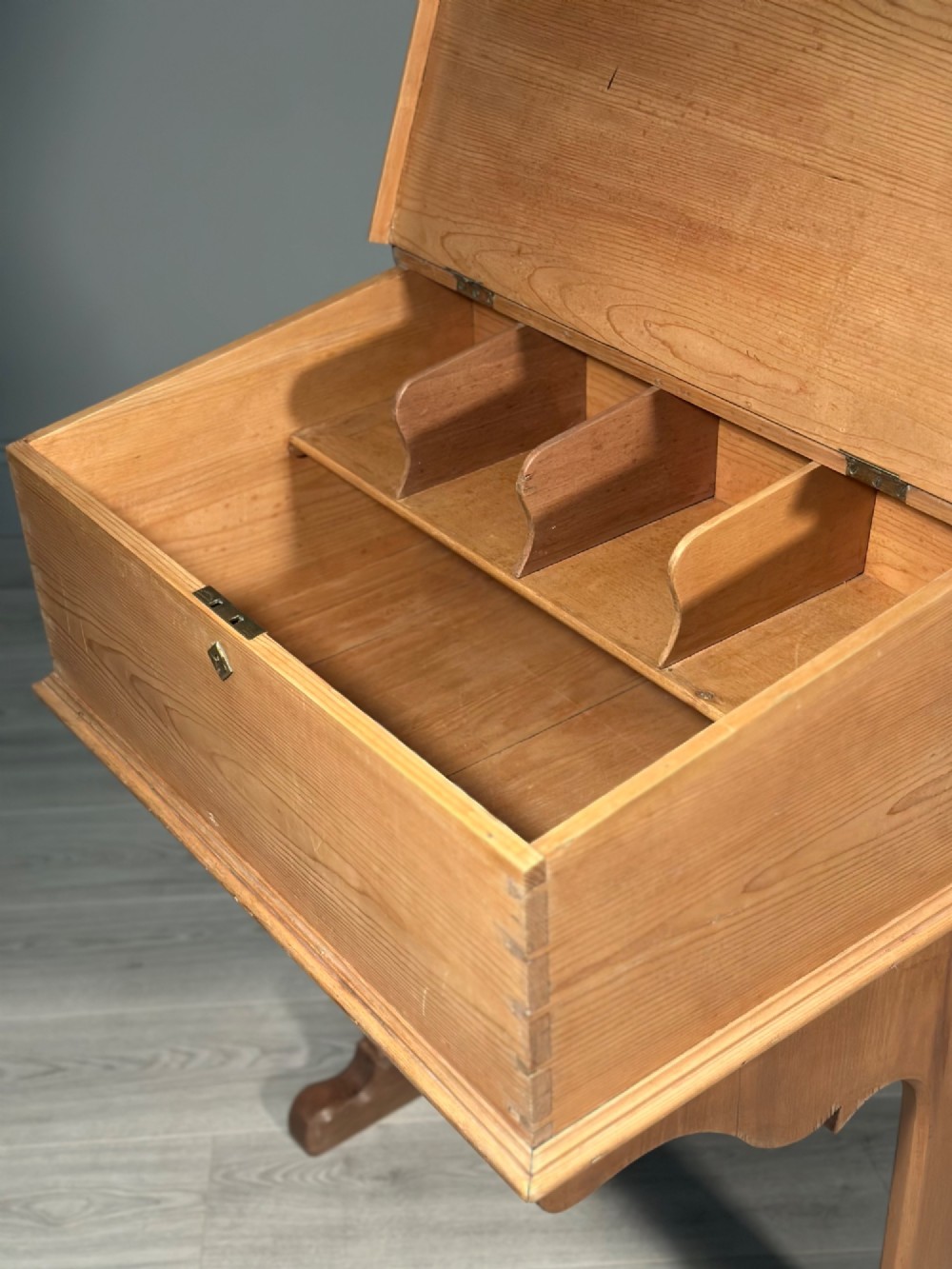 A Victorian pine school desk featuring a slanted hinged lid, dovetail joinery, shaped side supports, and a raised back gallery. View IV