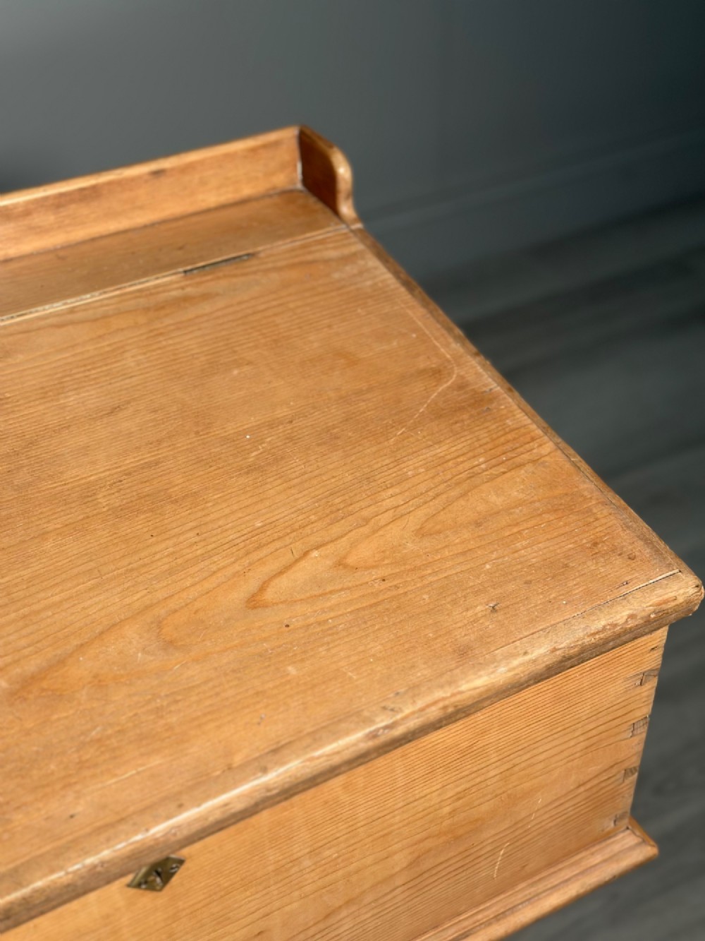 A Victorian pine school desk featuring a slanted hinged lid, dovetail joinery, shaped side supports, and a raised back gallery. View VIII