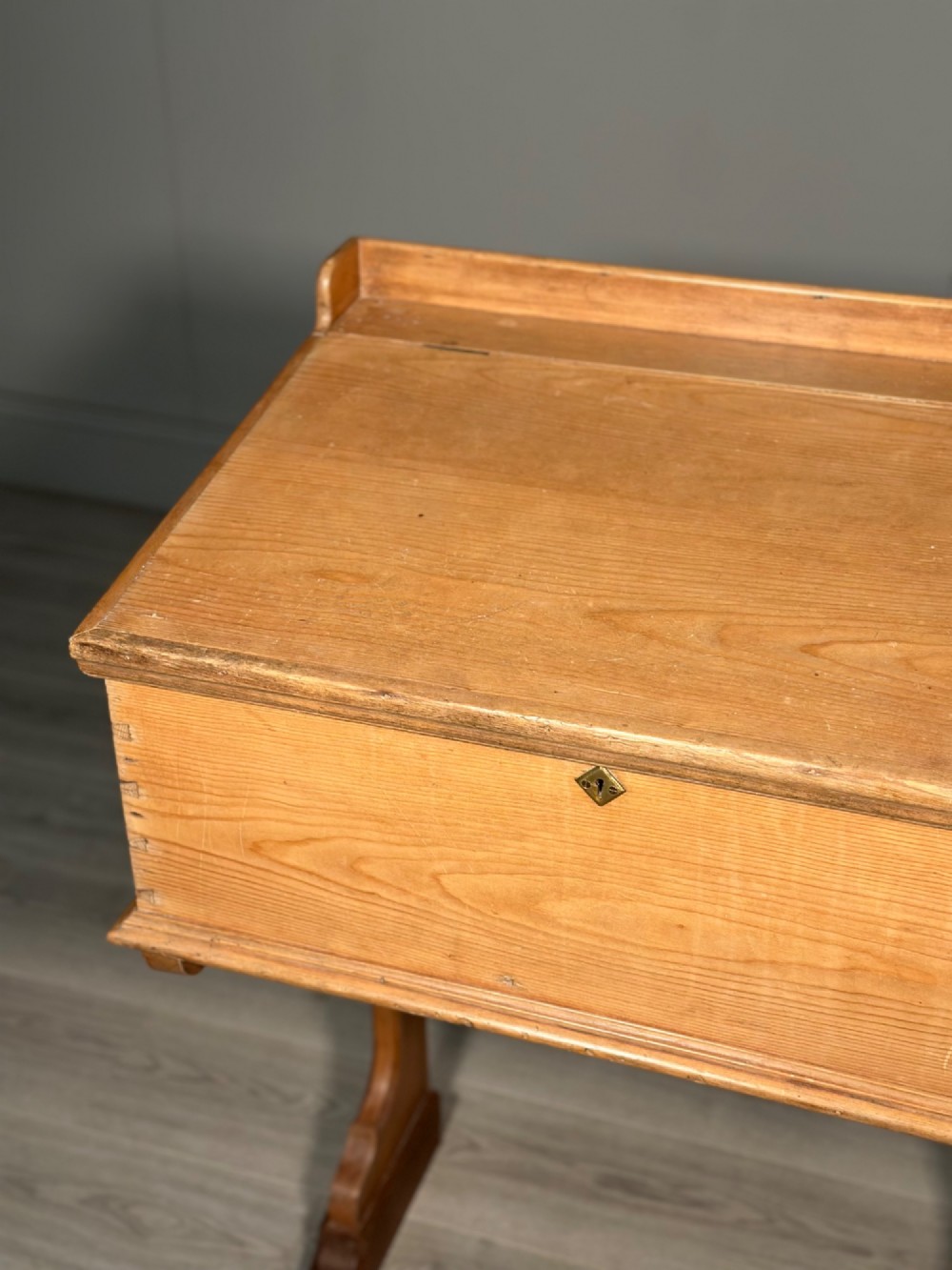 A Victorian pine school desk featuring a slanted hinged lid, dovetail joinery, shaped side supports, and a raised back gallery. View IX