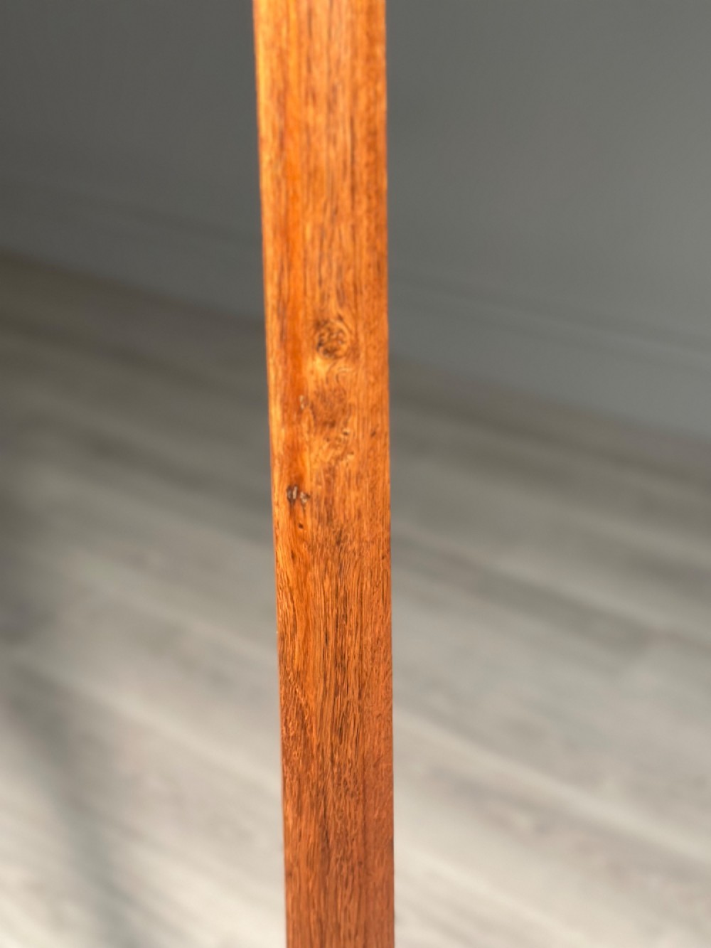A tall Arts and Crafts solid oak standard lamp featuring a faceted stem mounted on an octagonal base with a brass light socket. View VII
