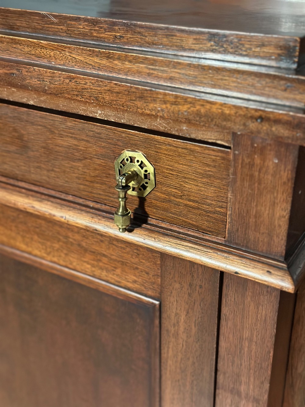 An Edwardian mahogany pedestal sideboard featuring two outer pedestal cupboards, central drawers, and brass drop handles. View VIII