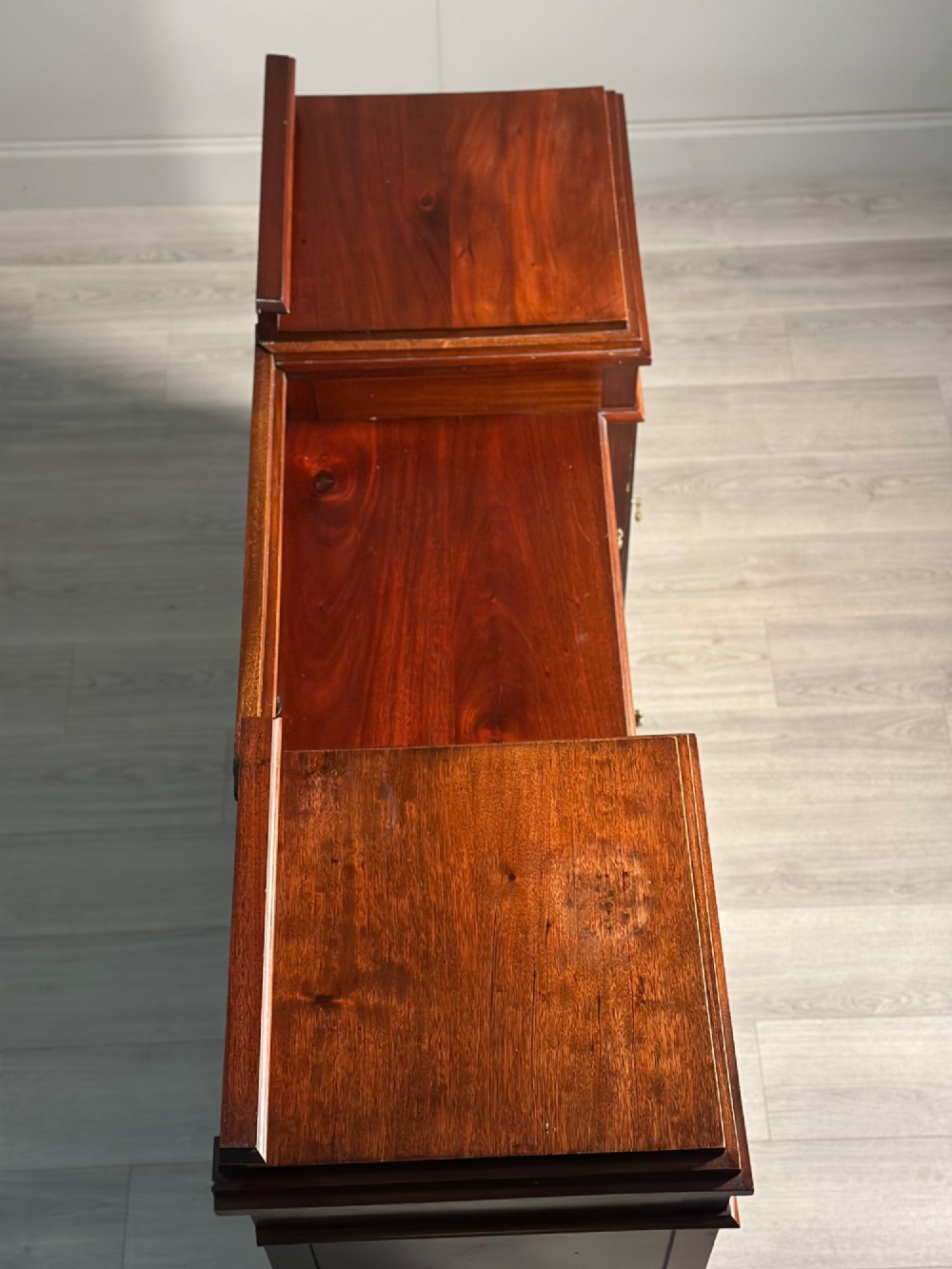 An Edwardian mahogany pedestal sideboard featuring two outer pedestal cupboards, central drawers, and brass drop handles. View IX