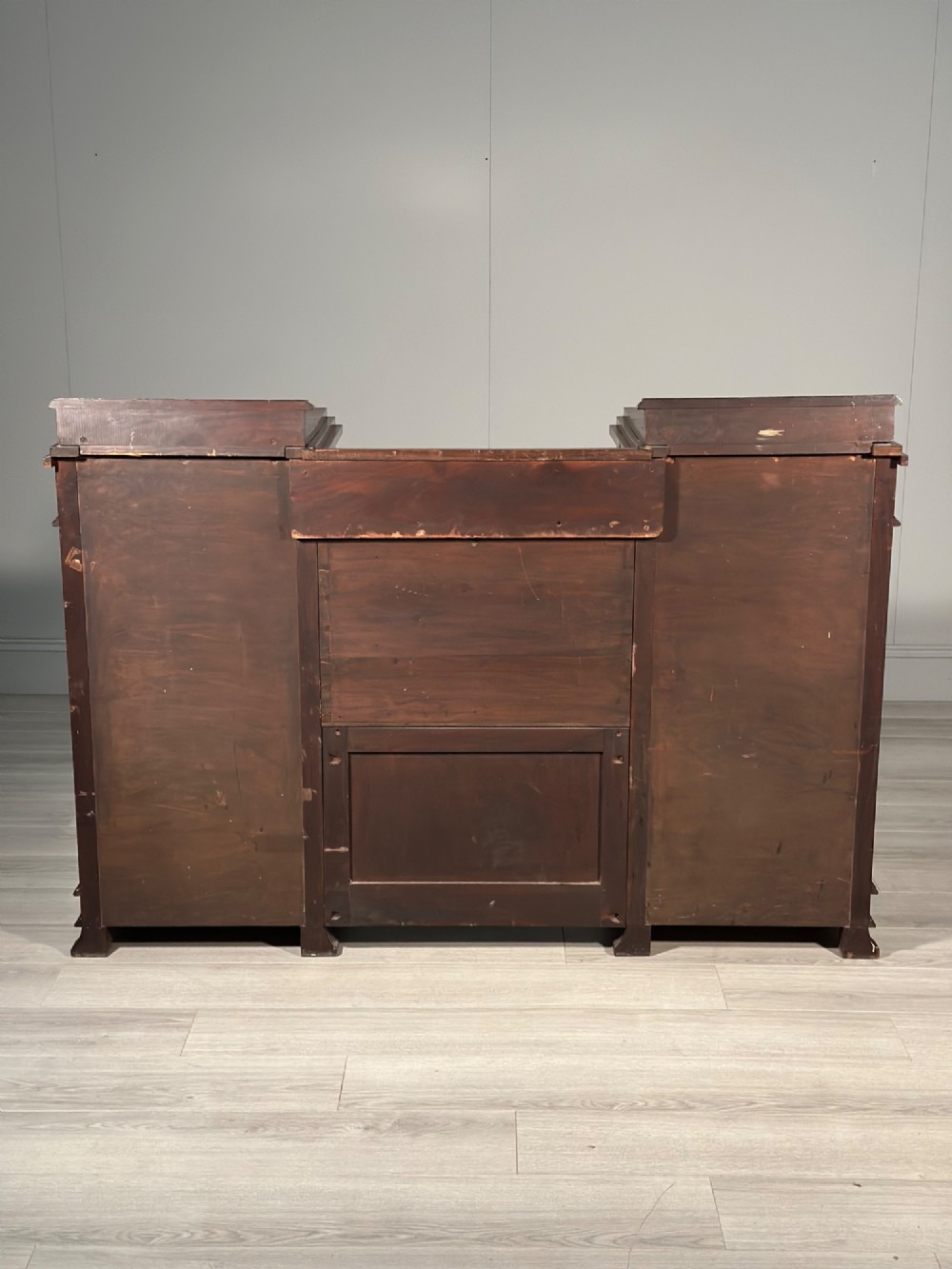 An Edwardian mahogany pedestal sideboard featuring two outer pedestal cupboards, central drawers, and brass drop handles. View XII