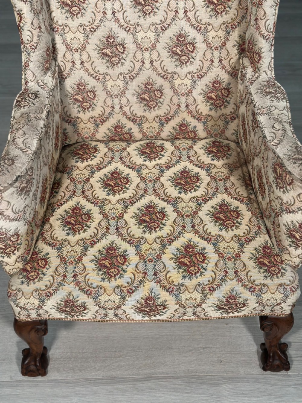 An Edwardian wingback armchair upholstered in cream floral patterned fabric with carved mahogany cabriole legs and ball-and-claw feet. View IV