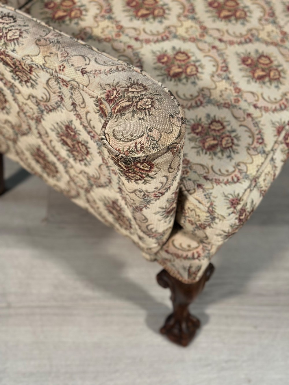 An Edwardian wingback armchair upholstered in cream floral patterned fabric with carved mahogany cabriole legs and ball-and-claw feet. View VIII