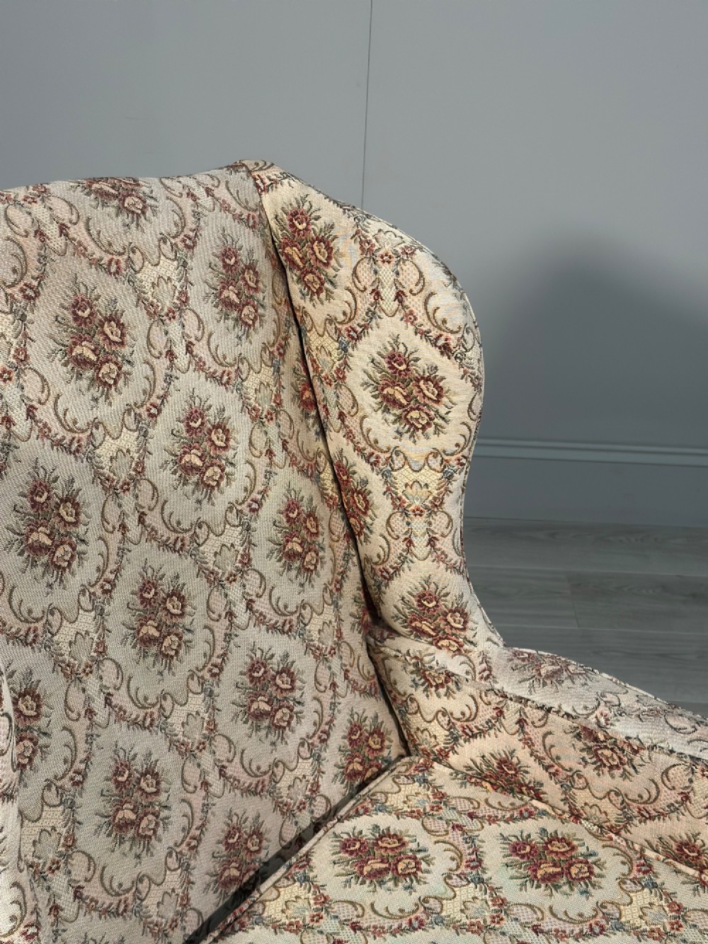 An Edwardian wingback armchair upholstered in cream floral patterned fabric with carved mahogany cabriole legs and ball-and-claw feet. View IX