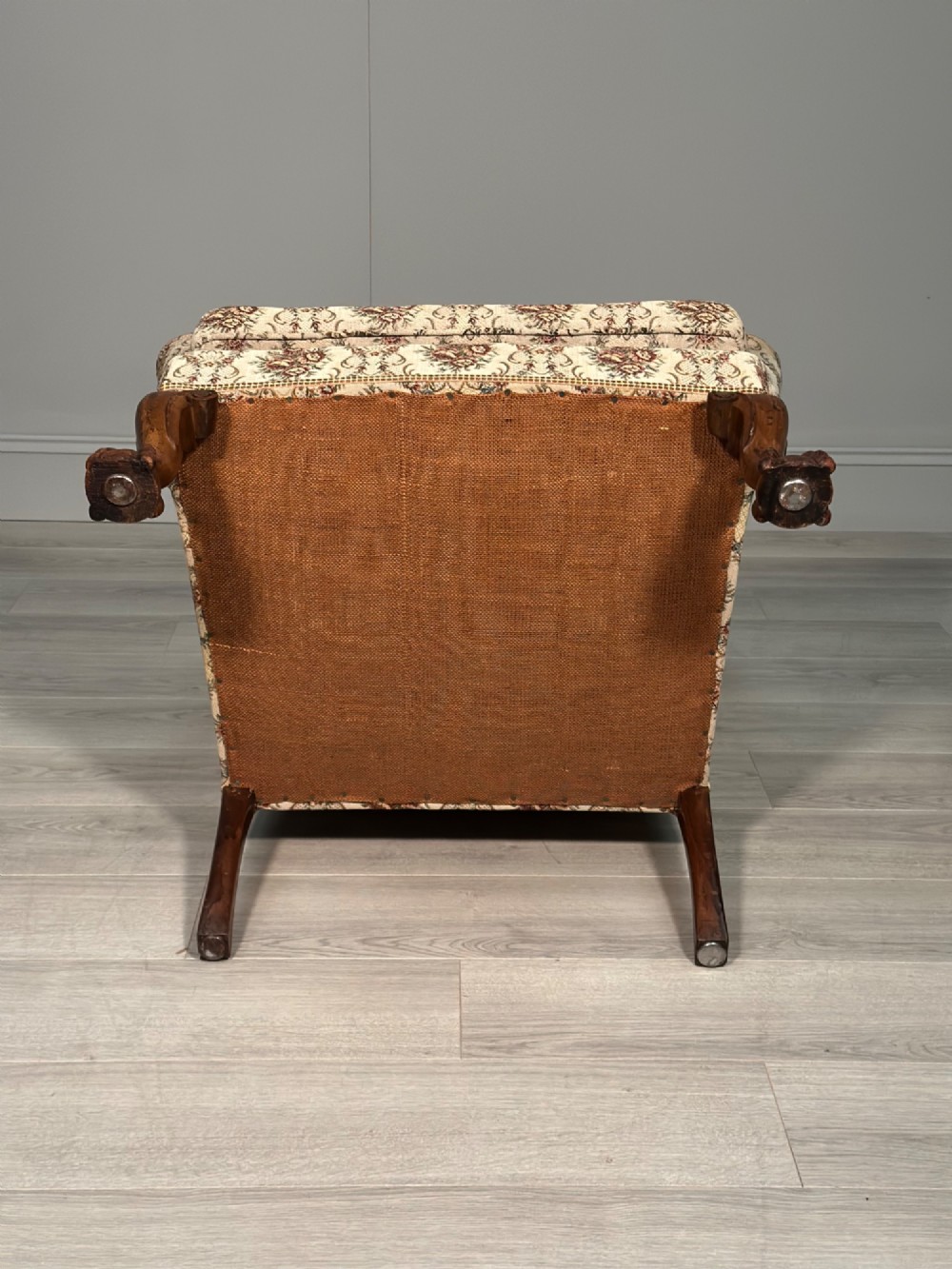 An Edwardian wingback armchair upholstered in cream floral patterned fabric with carved mahogany cabriole legs and ball-and-claw feet. View X