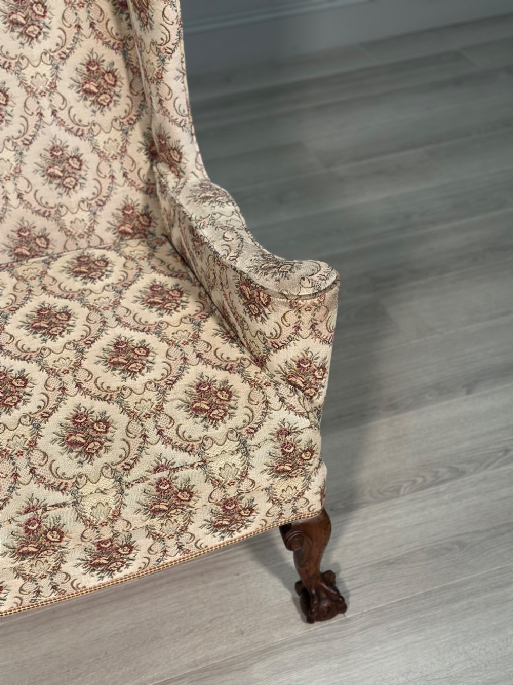 An Edwardian wingback armchair upholstered in cream floral patterned fabric with carved mahogany cabriole legs and ball-and-claw feet. View XIII