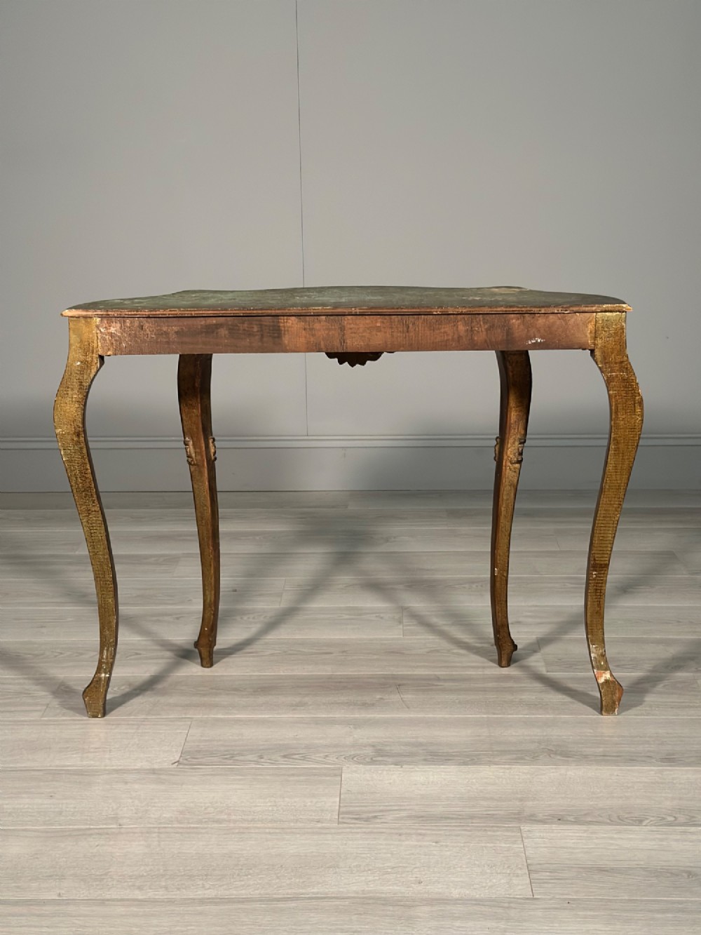 A Rococo style carved giltwood console table featuring cabriole legs, central shell motif, serpentine apron, and a dark marble top. View XIII
