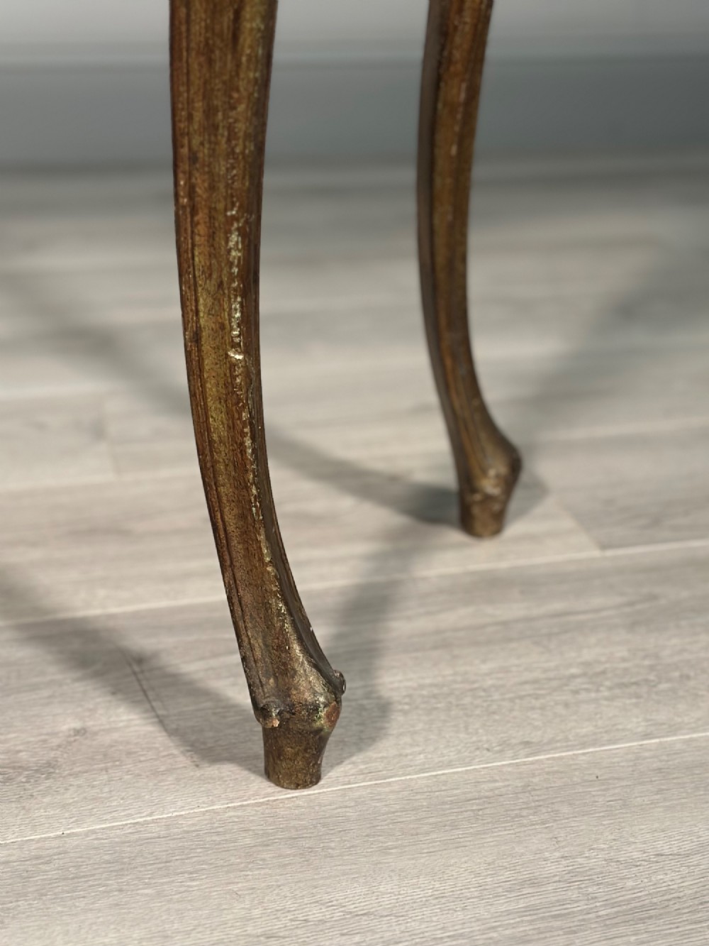 A Rococo style carved giltwood console table featuring cabriole legs, central shell motif, serpentine apron, and a dark marble top. View XIV