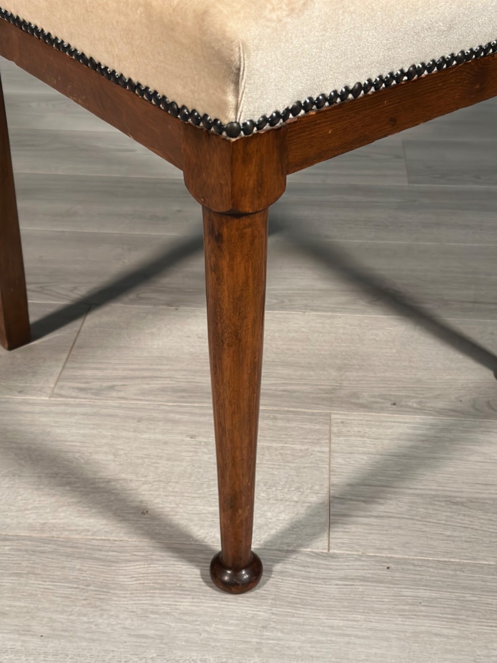 A set of four antique Biedermeier dining chairs featuring carved wooden frames, pierced back splats, and cream upholstered seats with brass stud detailing. View XI