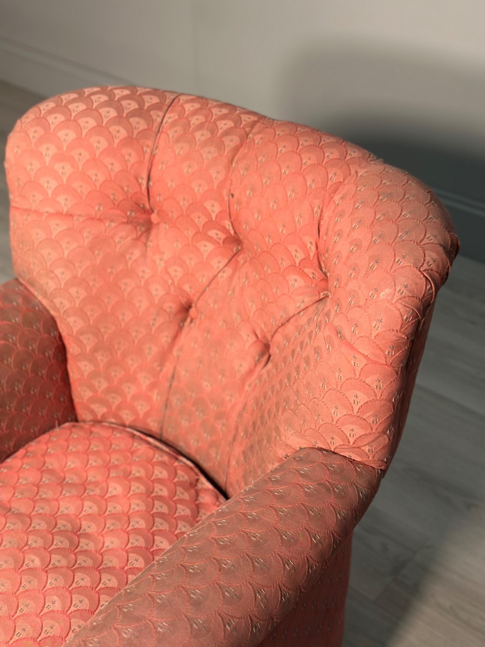 A Victorian button-back armchair upholstered in dusty pink patterned fabric with turned wooden front legs on brass castors. View VI