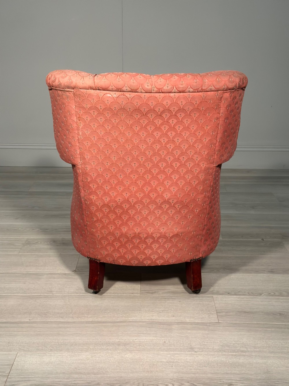 A Victorian button-back armchair upholstered in dusty pink patterned fabric with turned wooden front legs on brass castors. View VIII