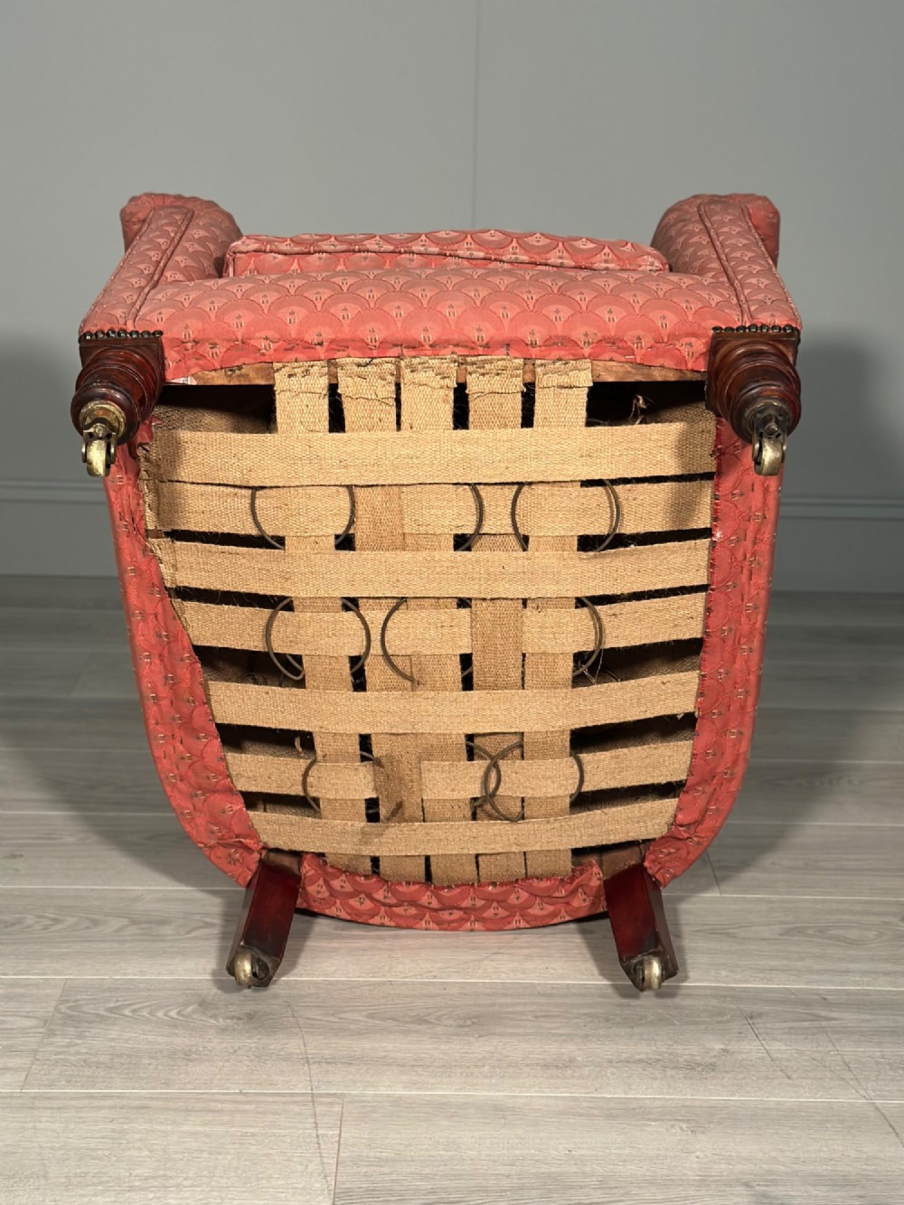 A Victorian button-back armchair upholstered in dusty pink patterned fabric with turned wooden front legs on brass castors. View XIII