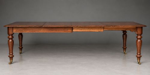 fig 1. A Victorian mahogany extending dining table with turned legs resting on brass castors and an expanding rectangular top.