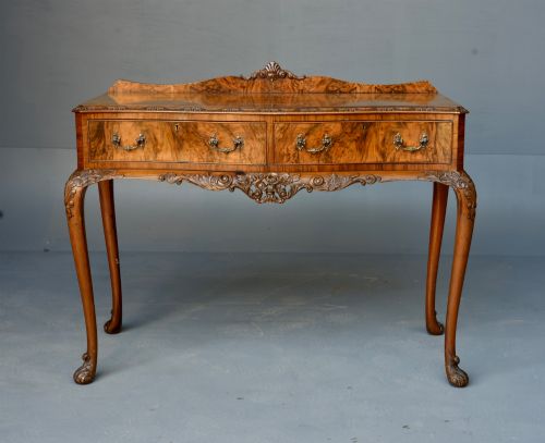 fig 1. A Queen Anne style burr walnut side table featuring two drawers with brass handles, carved cabriole legs, and a raised gallery top.