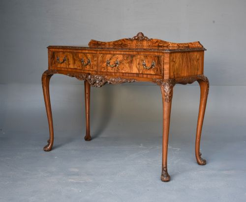fig 2. A Queen Anne style burr walnut side table featuring two drawers with brass handles, carved cabriole legs, and a raised gallery top.