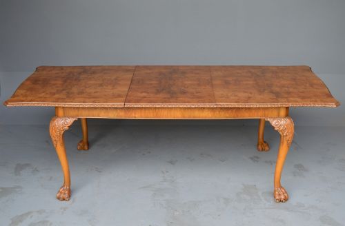 fig 1. A figured walnut Queen Anne style extending dining table surrounded by eight matching splat-back chairs with carved cabriole legs and upholstered seat cushions.