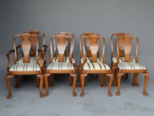 fig 2. A figured walnut Queen Anne style extending dining table surrounded by eight matching splat-back chairs with carved cabriole legs and upholstered seat cushions.