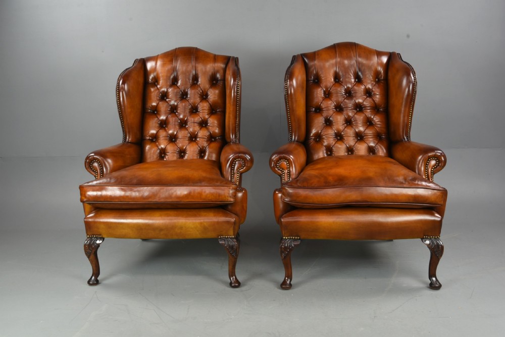 Antique pair of deep buttoned leather wing chairs 