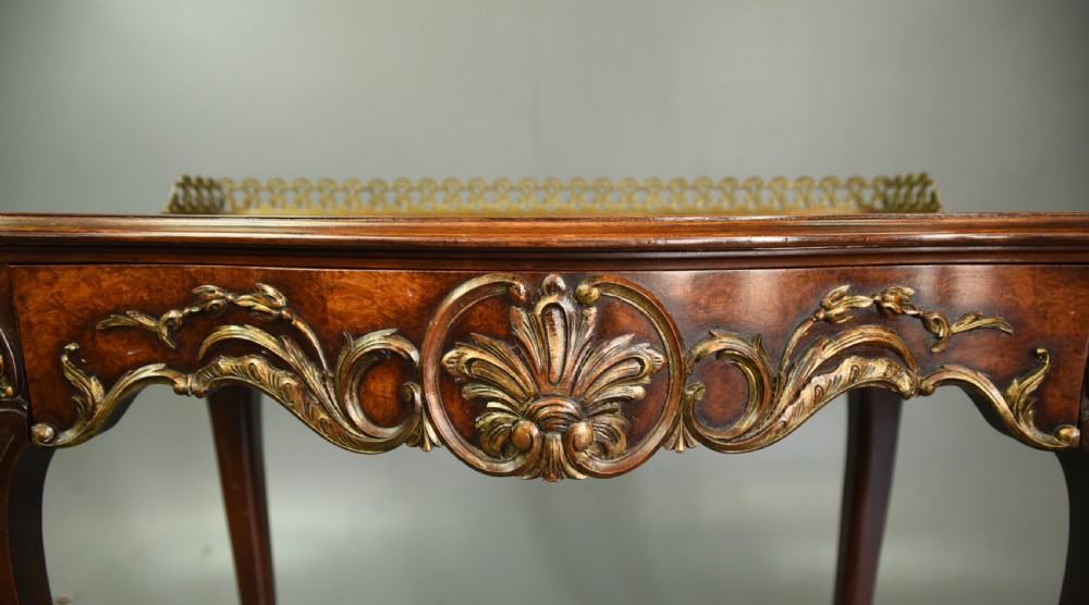 A 19th-century walnut side table with serpentine edges, ornate gilt metal mounts, cabriole legs, and a pierced brass gallery rail. View IX