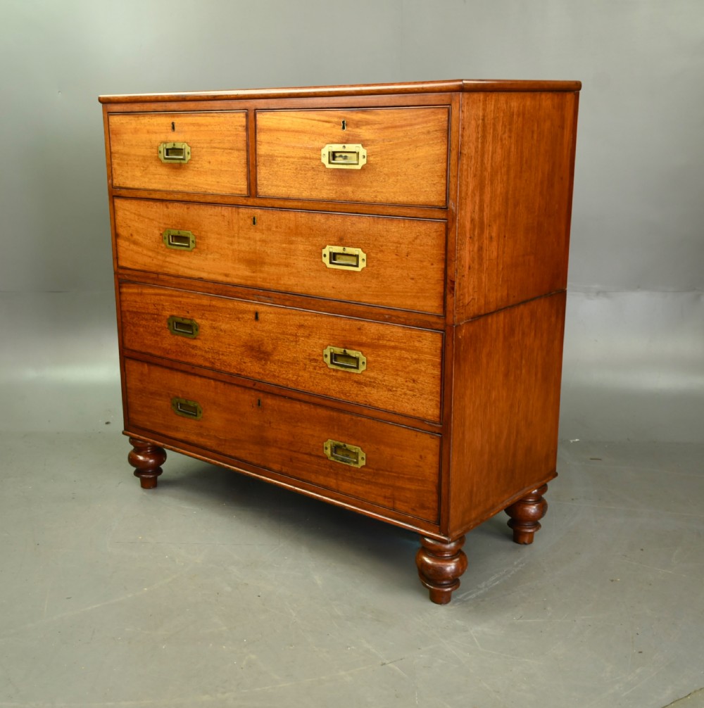 A Victorian mahogany military campaign chest featuring flush recessed brass handles, brass corner mountings, and a two-part construction resting on turned feet. View II