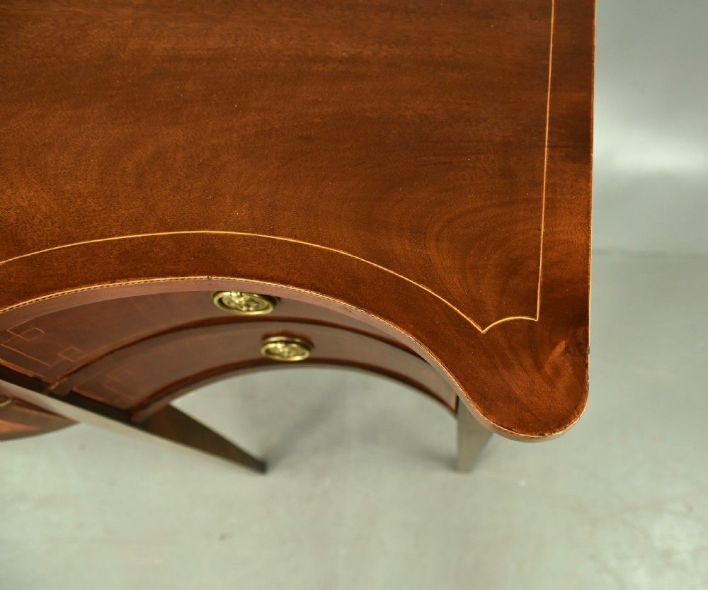A Regency mahogany serpentine sideboard featuring curved drawer fronts, floral marquetry inlay, cast brass ring handles, and six tapered legs. View VIII