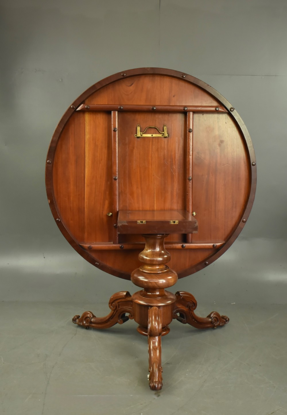 A round Victorian rosewood centre dining table featuring a figured timber top and a carved tripartite pedestal base. View IV