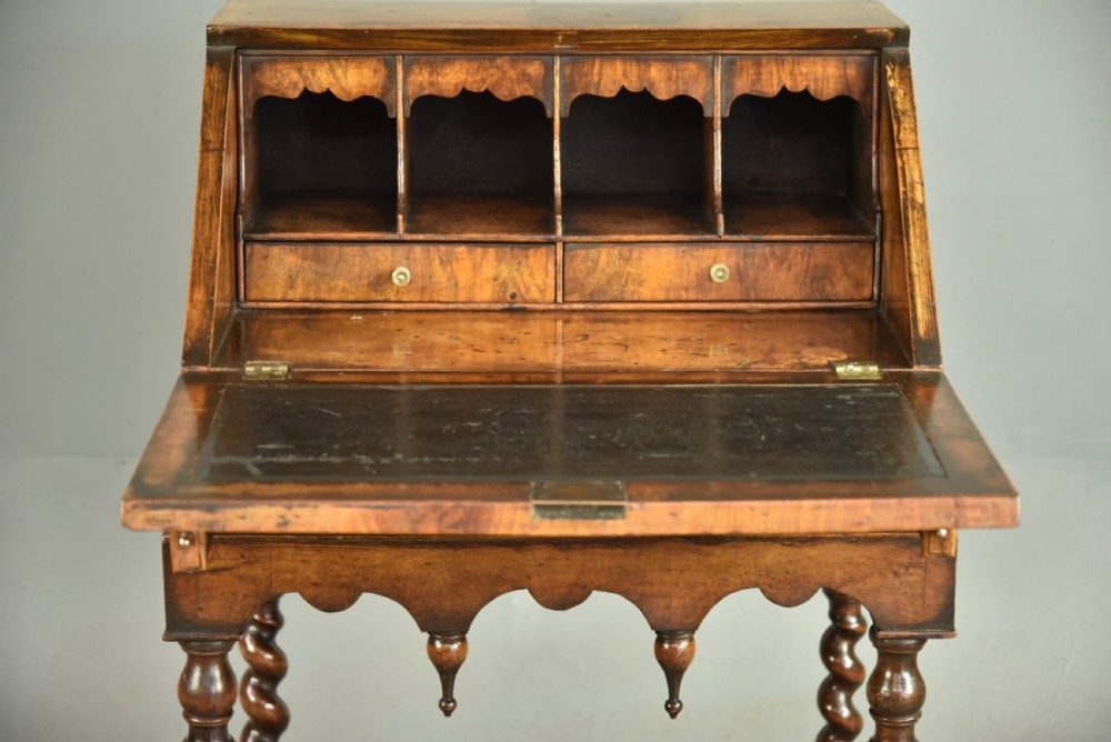 A small walnut bureau featuring an oval floral marquetry panel on the sloped front, set above a drawer and supported by four barley twist legs. View III