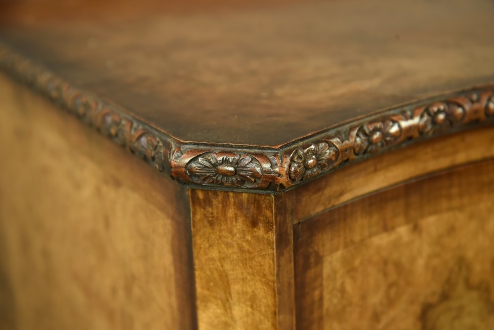 A Queen Anne style burr walnut sideboard featuring central drawers, flanking cupboard doors, carved shell detail, and cabriole legs. View VI