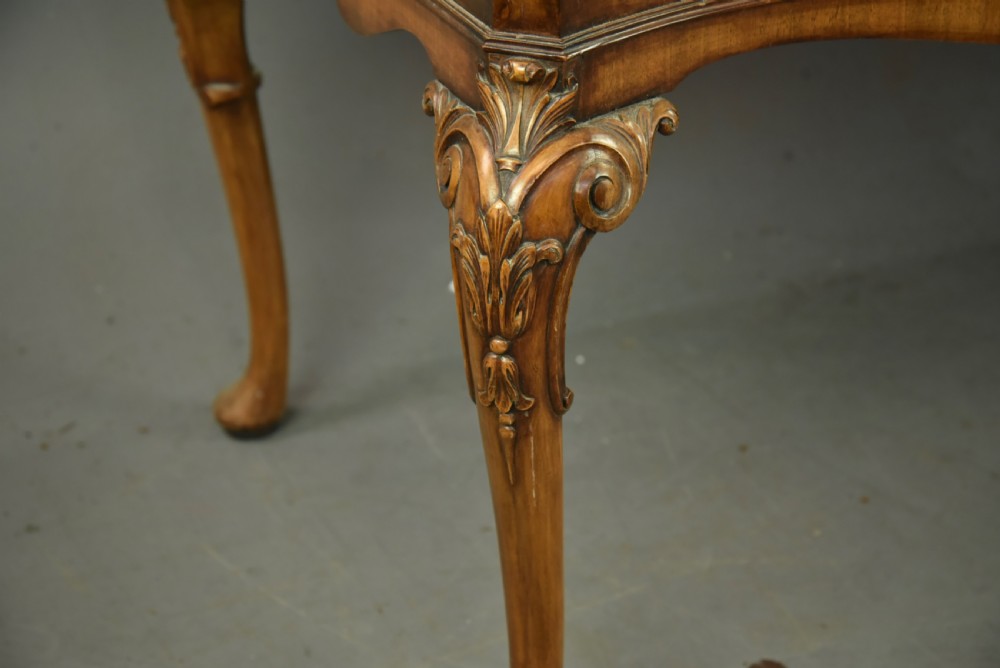 A Queen Anne style burr walnut sideboard featuring central drawers, flanking cupboard doors, carved shell detail, and cabriole legs. View VII
