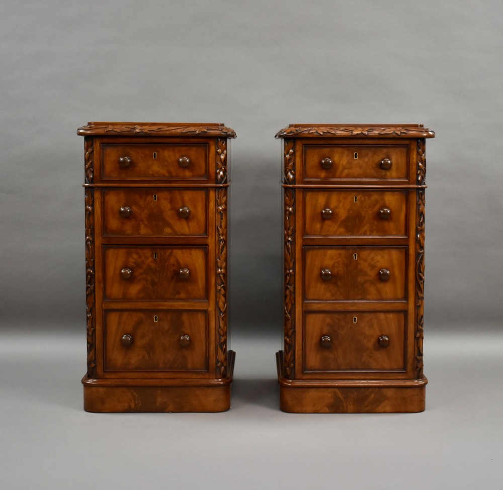A pair of tall Victorian mahogany bedside chests with four drawers each, carved foliate columns, and turned wooden knobs on plinth bases. View II