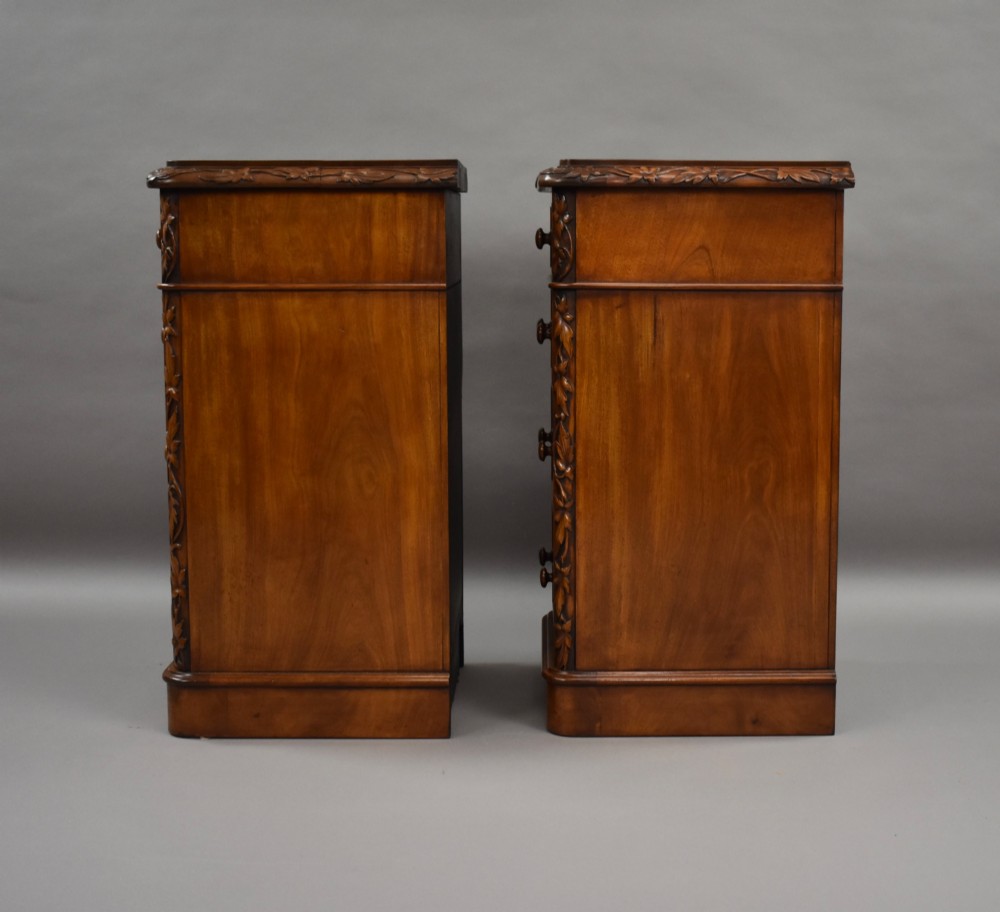 A pair of tall Victorian mahogany bedside chests with four drawers each, carved foliate columns, and turned wooden knobs on plinth bases. View VI