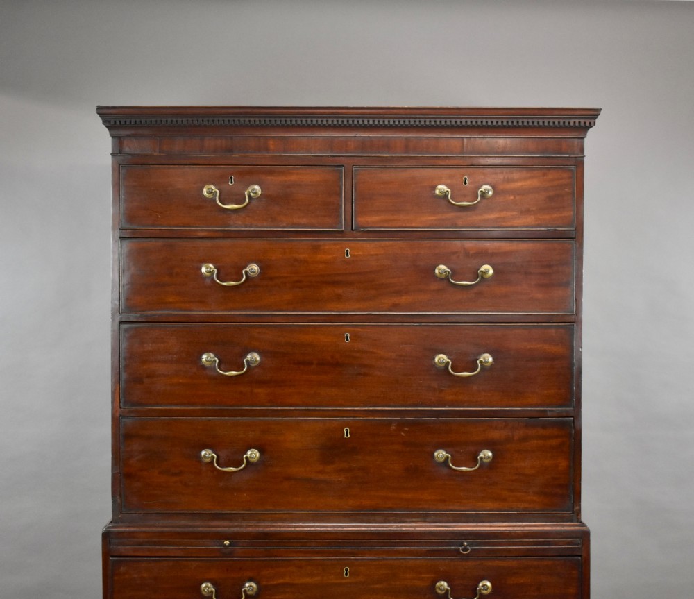 A two-section Georgian mahogany chest on chest featuring multiple drawers with brass swan-neck handles, a dentil cornice, and bracket feet. View II