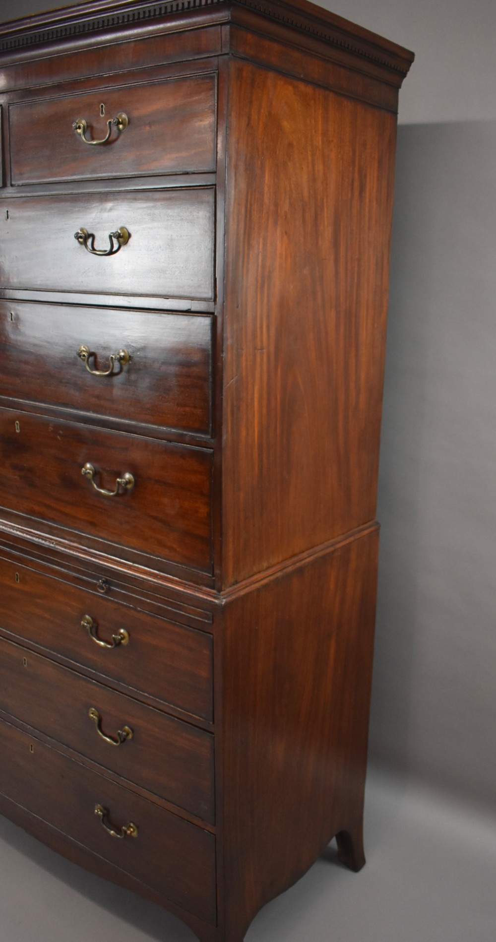 A two-section Georgian mahogany chest on chest featuring multiple drawers with brass swan-neck handles, a dentil cornice, and bracket feet. View V