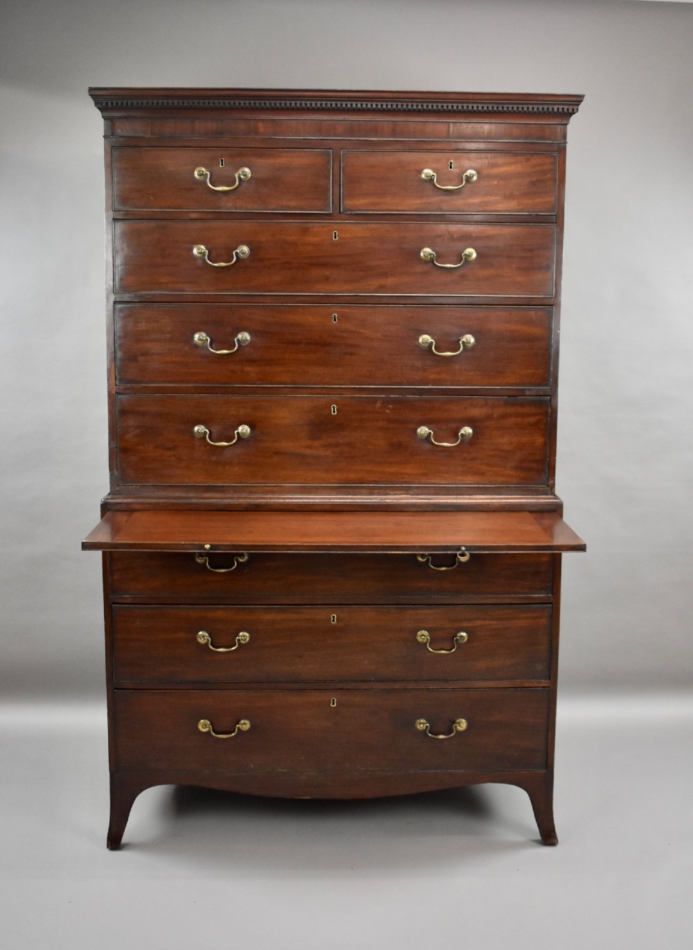 A two-section Georgian mahogany chest on chest featuring multiple drawers with brass swan-neck handles, a dentil cornice, and bracket feet. View VII