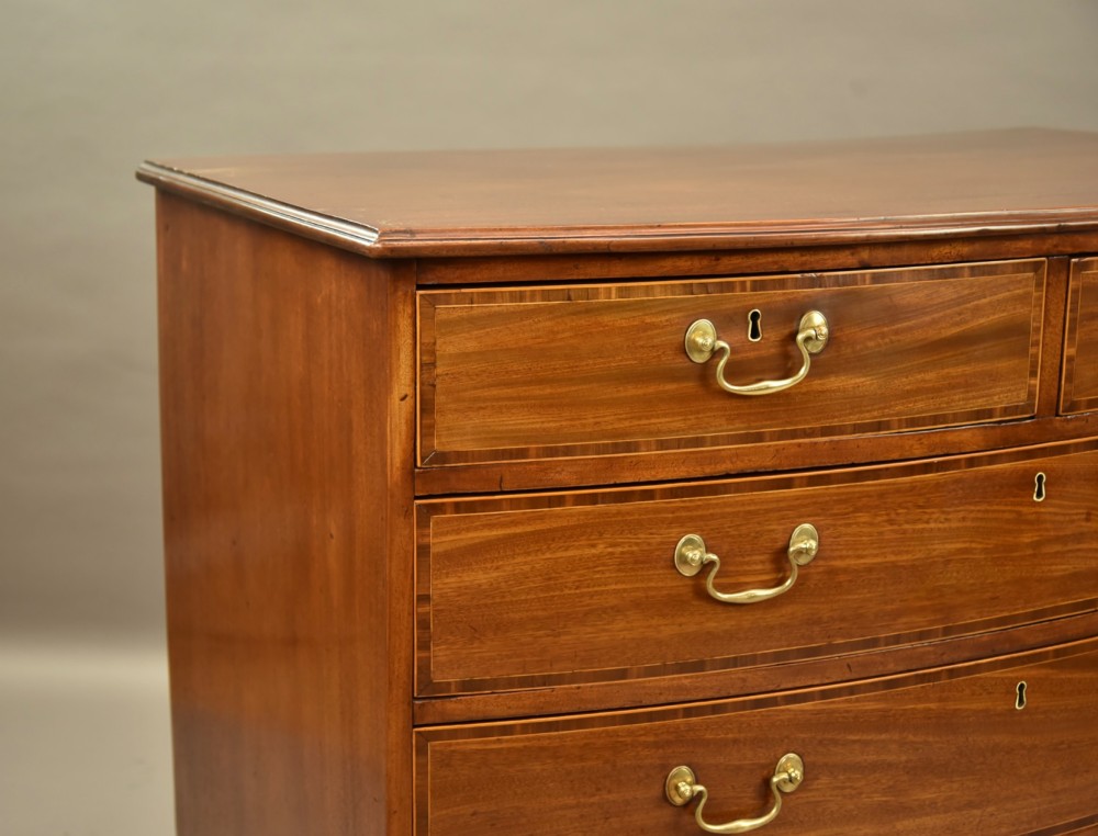 A 19th-century mahogany bowfront chest of drawers featuring two short over three long drawers with brass handles. View VII