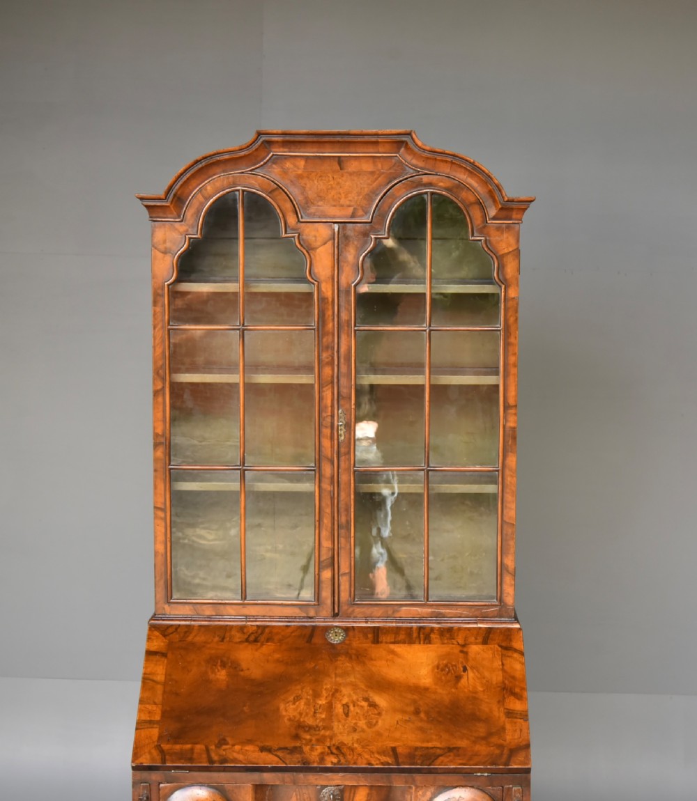 An antique Queen Anne style bureau bookcase in warm walnut featuring a double-domed glazed top section above a slant-front bureau and three drawers on cabriole legs. View V