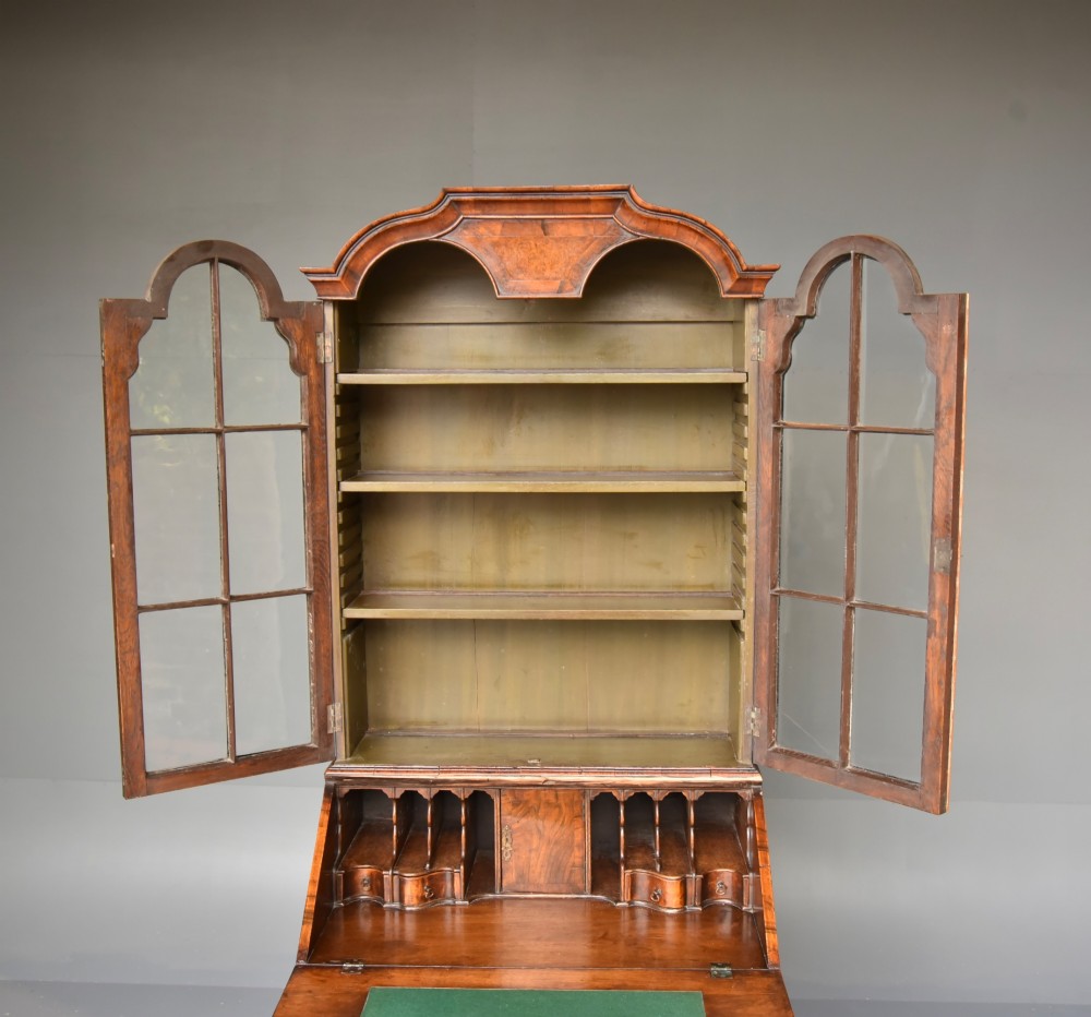 An antique Queen Anne style bureau bookcase in warm walnut featuring a double-domed glazed top section above a slant-front bureau and three drawers on cabriole legs. View VII