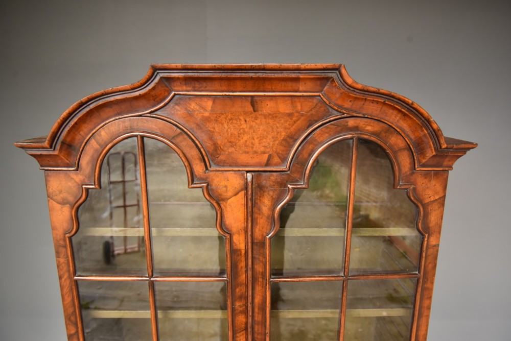 An antique Queen Anne style bureau bookcase in warm walnut featuring a double-domed glazed top section above a slant-front bureau and three drawers on cabriole legs. View VIII
