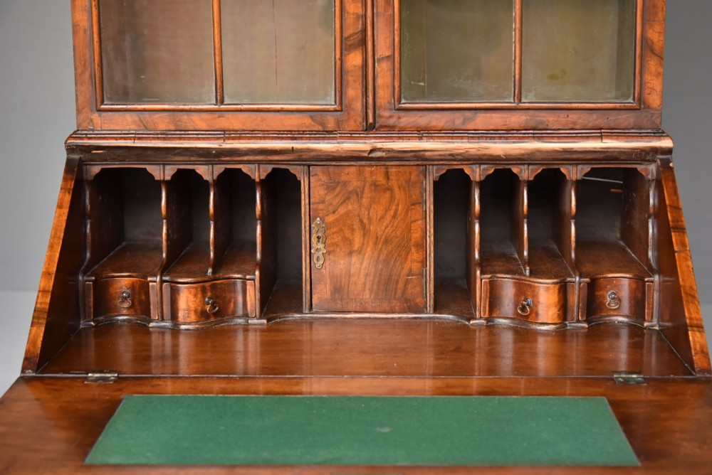 An antique Queen Anne style bureau bookcase in warm walnut featuring a double-domed glazed top section above a slant-front bureau and three drawers on cabriole legs. View IX