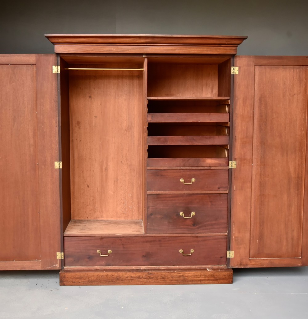 A Victorian mahogany double wardrobe featuring two panelled doors, a projecting moulded cornice, and a sturdy plinth base. View II