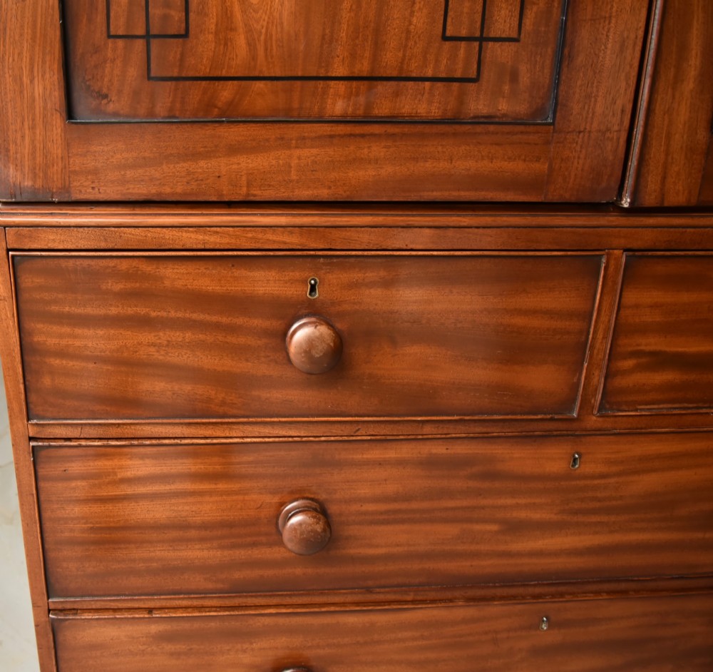 A Georgian mahogany gentlemans wardrobe featuring a two-door upper section with ebony line inlay over a base of two short and two long drawers on bracket feet. View VII